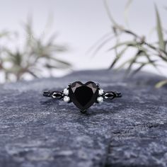 a black diamond ring sitting on top of a rock