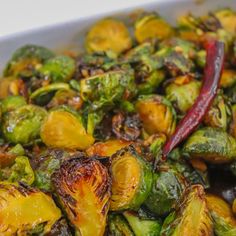 brussel sprouts with red peppers in a white casserole dish