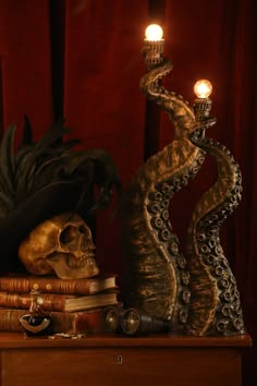 a skull with a hat on top of it next to some books and a candle