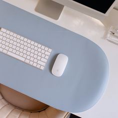 a computer keyboard sitting on top of a desk next to a monitor and mouse pad