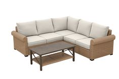 a wicker couch and coffee table with white cushions