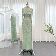 This garment is categorized as an evening dress and is intended for formal occasions. It is manufactured in the Jiangsu province in Mainland China by the brand Sharon Said. The neckline is strapless and the length is a sweep train.. The dress is adorned with beading, crystals, pearls, and sequins, and has a trumpet/mermaid silhouette. The sleeve length is sleeveless and the dress falls to the floor. The fabric used is tulle and the waistline is natural. The dress is not customizable and features a built-in bra. The style is modern with elements of beads. It is appropriate for all ages and features a striped pattern. Sleeveless Green Evening Ball Gown, Sleeveless Green Ball Gown For Evening, Elegant Green Ball Gown, Green Evening Dress With Sweep Train For Banquet, Elegant Strapless Dress For Banquet And Gala, Elegant Strapless Dress For Gala Banquet, Strapless Evening Dress With Sweep Train For Banquet, Strapless Evening Dress For Banquets, Strapless Dress For Banquet Gala