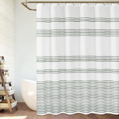 a bathroom with a white shower curtain and wood flooring