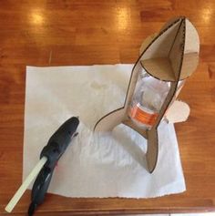 an open cardboard box sitting on top of a wooden table next to a bottle opener