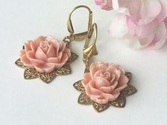 Filigree flower shaped brass bases have coral pink coloured roses attached. Shell adorned brass lever backs finish the look. In the Victorian language of flowers coral coloured roses meant desire. Limited edition design. Brass lever backs. Length (from top of ear wire to bottom of earring) 3.7cm (1.45 inches). For more beautiful and unusual handmade earrings please visit: www.etsy.com/uk/shop/HandmadeEarringsUk Vintage Rose Gold Flower Earrings, Vintage Brass Flower Earrings, Vintage Pink Nickel-free Flower Earrings, Vintage Rose Gold Flower Earrings Gift, Rose Gold Vintage Flower Earrings For Gift, Vintage Rose Gold Flower Earrings For Wedding, Victorian Language Of Flowers, Victorian Language, Coloured Roses