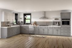 a large kitchen with wooden floors and gray cabinets