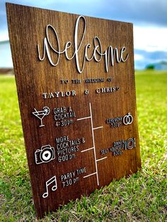 a wooden welcome sign sitting in the grass