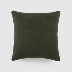 a dark green pillow on a white background