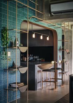 a room with blue tiles and gold barstools in front of the bar area