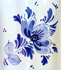 a blue and white vase with flowers painted on it