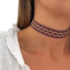 Our Choker AMEROK necklace is embroidered with gold and purple thread, with geometric shapes. It is adjustable with extension, so you can adjust it to the extent you like, leaving it stuck to the neck or a little looser! It is perfect to wear on a day-to-day basis or on special occasions. It is boho style - minimalist, it looks beautiful put! Without a doubt a good option to give or for yourself! All our jewelry can get wet. -MATERIAL: * Gold plated closure 18 kt - LONG FABRIC: * 30 cm with exte Gold Woven Jewelry For Festival, Bohemian Purple Choker For Festivals, Purple Bohemian Choker For Festivals, Trendy Woven Jewelry For Festivals, Adjustable Bohemian Choker, Woven Thread Jewelry For Festivals, Handmade Thread Jewelry In Gold, Adjustable Gold Thread Jewelry, Bohemian Handmade Choker