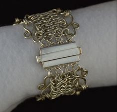 "This sterling silver wide bracelet is a chainmaille which is round links woven together to form the pattern. This one can be dressed up or down and is made to be passed on for generations. Each link is hand made. The bracelet is 1-1/2\" wide and the entire bracelet weighs 1.75 oz. It is very smooth to the touch and will not catch on your clothing. (doesn't that drive you nuts when they do?). The solid sterling silver clasp works by squeezing the ends to insert the prongs of the other half or to Elegant Chainmail Bracelets As Gift, Elegant Chainmail Bracelet Gift, Handmade White Gold Metal Chain Bracelet, Elegant Chainmail Bracelets For Gift, Elegant Chainmail Bracelet For Gift, Handmade White Gold Chain Bracelet, Silver Chainmail Chain Link Bracelets, Silver Chainmail Bracelet With Chain Link, Silver Link Chain Bracelet With Box Clasp