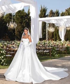 a woman in a wedding dress standing under an arch