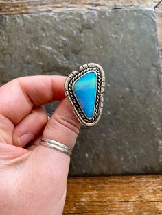 Handmade Aurora Opal and sterling silver ring.  -Ring will fit US size 9  Beautiful and unique Aurora Opal!!  Pale blueish-lavender color with amazing cotton candy pink flash! Pinks, blues, purples and greens mixed in this Opal. Cut out border design. Double, chunky style ring band.   100% Sterling silver. --------------------- Every piece will come packaged in a recycled kraft paper jewelry box. We ship worldwide. Check out our other listings! and follow us on Instagram for shop updates! Please Unique Blue Turquoise Ring, Bohemian Blue Opal Ring In Sterling Silver, Blue Opal Ring In Sterling Silver, Bohemian Style, Blue Bohemian Opal Ring In Sterling Silver, Blue Opal Open Ring In Sterling Silver, Artisan Blue Rings One Of A Kind, Artisan Blue Ring, Blue Cabochon Opal Ring In Sterling Silver, One Of A Kind Blue Sterling Silver Rings