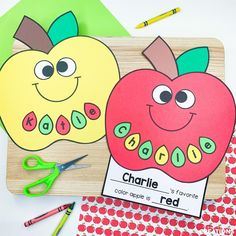 two apples cut out to look like children's name cards with scissors and crayons