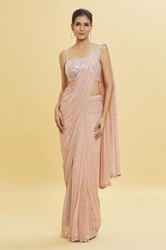 Blush pink pre-draped saree in georgette base with linear sequin embellishments and floral sequin embroidered borders. Comes with sleeveless strappy chevron pattern sequin work padded blouse. Components: 2 Pattern: Embroidery Type Of Work: Sequin Neckline: Square Neck Sleeve Type: Sleeveless Fabric: Georgette Color: Pink Other Details:  Padded blouse Closure: Blouse: Back hooks   Occasion: Party, Wedding - Aza Fashions Strappy Blouse Designs, Sequin Saree Blouse Designs, Grad Saree, Blush Pink Saree, Pink Sequin Saree, Bridesmaids Colors, Saree Colours, Farewell Saree, Cocktail Saree