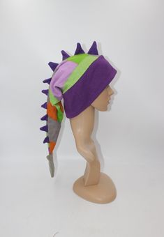 This listing is for the hat pictured, you will receive this exact hat.   With its eye-catching pattern and long row of spikes, everyone you encounter will wonder where you got such a great hat and will want one for themselves! Hat is sized to fit any ages from 4 years old and up- fits kids, adults, and teens alike. Extra stretchy, wonderfully warm band with ear flaps make this hat perfect for anyone! Feel free to ask for a custom sized hat, we will make one in any mix of colors/patterns, sized j Adjustable Novelty Hats One Size, Playful Adjustable Beanie Hat, Adjustable Themed Cap Style Hat, Adjustable Themed Cap, Themed Adjustable Cap, Adjustable Warm Winter Costume Hats And Headpieces, Fitted Beanie For Festivals, Warm Adjustable Festival Hat, Playful Adjustable Winter Costume Hats And Headpieces