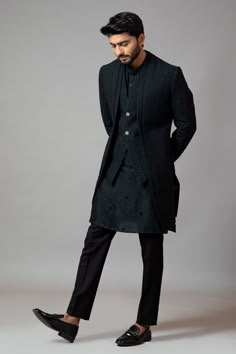 a man in a long coat and black shoes