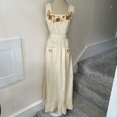 Vintage 1970s Beige Cotton Prairie Cottagecore Floral Embroidered Maxi Dress XS. Gorgeous vintage prairie cottagecore style maxi dress from the late 1960s/early 1970s from the hippie bohemian era. Has gorgeous floral embroidery throughout. Two front pockets. Back zip. Attached back tie belt. Extra fabric at hem interior for alteration purposes. Made in Ecuador. Has minor staining/discoloration throughout, but in overall lovely vintage condition with a ton of life left. I have no tried to get the Summer Retro Embroidered Dress, Retro Embroidered Summer Dress, Retro Embroidered Cotton Dress, Spring Vintage Cotton Embroidered Dress, Vintage Cotton Embroidered Dress For Spring, Vintage Embroidered Sleeveless Dress, Vintage Sleeveless Embroidered Dress, Vintage Embroidered Fitted Summer Dress, Vintage Cotton Dress With Floral Embroidery