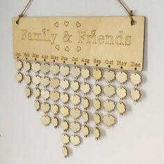 a family and friends sign hanging on a wall with hearts attached to the back of it