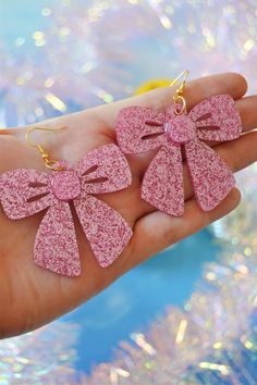 "Perfect for showing off the fact that you ARE the present are these pink glittery bow earrings! Made of laser-cut acrylic in the most gorgeous bubblegum pink glitter acrylic, they're fashioned to look like adorable gift bows and finished with hypoallergenic gold-plated brass fishhooks for closure. Materials: acrylic, hypoallergenic gold-plated brass hardware Measurements: 2.9\" drop length, 2.5\" width" Pink Bow Jewelry For Valentine's Day Party, Valentine's Day Pink Bow Jewelry For Party, Valentine's Day Party Jewelry With Pink Bow, Pink Bow Earrings In Cute Style, Cute Pink Earrings With Pink Bow, Pink Earrings For Valentine's Day Party, Pink Bow Jewelry For Party, Cute Party Earrings For Valentine's Day, Pink Party Jewelry With Bow Detail