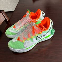 an orange and green sneaker is sitting on a table