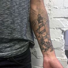 a man with a lighthouse tattoo on his arm