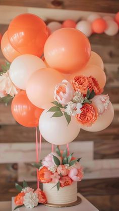 an arrangement of balloons and flowers on a table