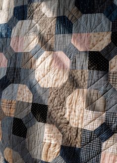 an old quilt is being displayed on a tablecloth that has been turned into a wall hanging