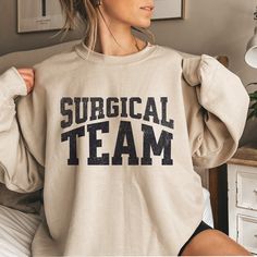 Surgical Team Shirt Operating Room Nurse Shirt Surgical Tech Shirts Surgery Squad OR Nurse Tees Surgeon Thank You Gift Scrub Tech ABOUT: :) This pre-shrunk, classic fit sweatshirt is made with air-jet spun yarn for a soft feel and reduced pilling. :) Pre-shrunk :) Classic fit with no center crease :) 1x1 athletic rib knit collar with spandex :) Air-jet spun yarn with a soft feel and reduced pilling :) Double-needle stitched collar, shoulders, armholes, cuffs, and hem: 50% preshrunk cotton, 50% polyester and like colors. SIZING: :) The sweater used is the Gildan 18000 Unisex Heavy Blend Crewneck Sweatshirt :) Sweatshirts are UNISEX so please refer to sizing chart in photos CARE INSTRUCTIONS: :) Garments should be machine-washed cold, inside-out on a gentle cycle with a mild detergent DESIGN Beach Sweatshirt, Jersey Vintage, Future Mrs, Vancouver Canucks, Baseball Shirt, Boston Massachusetts, Mom Sweatshirt, The Dark Side, Softest Sweater