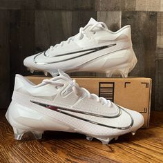 a pair of white nike soccer cleats sitting on top of a box