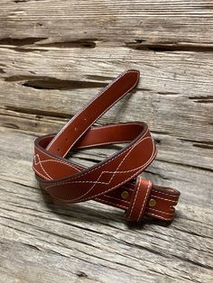 This chestnut-colored belt is crafted from English Bridle Strap Leather. Stitched with a unique geometric pattern, this belt would make a great addition to your closet. Please place your order 3 to 4 weeks before needed. Artisan Brown Belt Buckle With Belt Included, Brown Leather Belt With Embroidery, Brown Embroidered Leather Belt, Artisan Brown Embroidered Belt, Western Brown Belt Buckles For Everyday Use, Adjustable Brown Bridle Leather Belt, Adjustable Embroidered Brown Belt, Adjustable Brown Embroidered Belt, Formal Brown Embroidered Belt