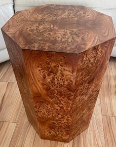 a wooden table sitting on top of a hard wood floor next to a white couch