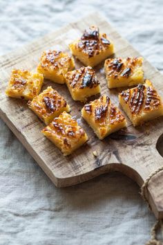 small pieces of food sitting on top of a wooden cutting board