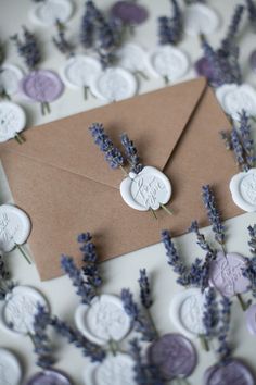 lavender flowers and wax seals on top of an envelope