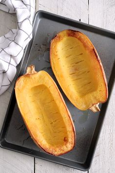 two halves of a squash on a baking sheet