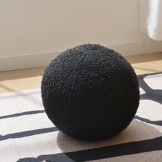 a large black ball sitting on top of a rug