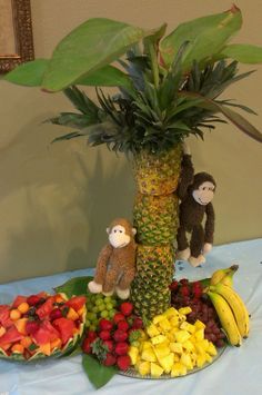 a table topped with bananas, pineapples and other fruit