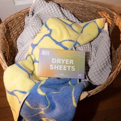 a basket filled with towels and blankets on top of a wooden floor