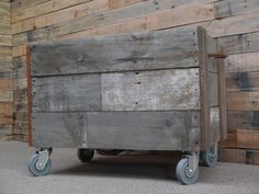 an old wooden wagon sitting in front of a wall with wood planks on it