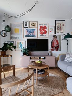 a living room filled with furniture and pictures on the wall above it's tv