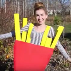 a woman is dressed up like a box with yellow sticks sticking out of it's sides