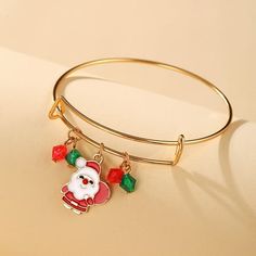 a gold bang bracelet with a santa clause charm