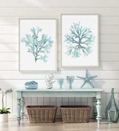 two blue sea plants are on the wall above a table with baskets and vases