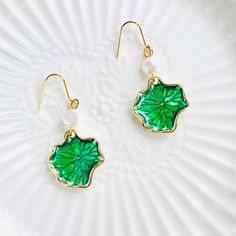 Enhance your look with our Lotus Leaf Pearl Hook Earrings. Featuring beautifully designed fresh green lotus leaves, these earrings are a unique and elegant addition to any outfit. The freshwater pearl appears as a delicate dewdrop resting on the lotus leaf. Upgrade your style and make a statement with these stunning earrings. Dimensions: 4.5cm*1.9cm Materials: 14k Gold-plated brass, freshwater pearl Green Hypoallergenic Flower-shaped Earrings, Hypoallergenic Green Flower-shaped Earrings, Green Pearl Drop Earrings As Gift, Green Flower Earrings For Pierced Ears, Green Flower Shaped Earrings As Gift, Green Flower Shaped Earrings Gift, Green Pearl Drop Earrings For Gift, Green Flower-shaped Earrings As Gift, Elegant Handmade Green Flower Earrings