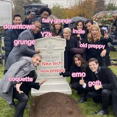 a group of people posing for a photo in front of a grave with words above it