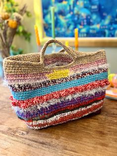 a multicolored bag sitting on top of a wooden table