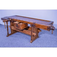 an old wooden work bench with drawers on the bottom and two wheels attached to it