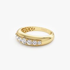 a yellow gold ring with three stones on the side and two rows of diamonds in each band