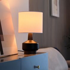 a table lamp sitting on top of a blue dresser